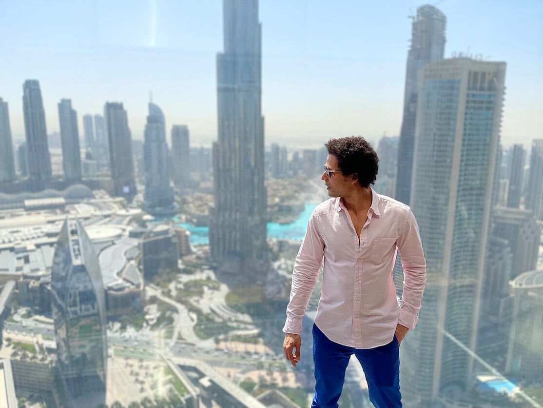A man standing at Sky Views Observatory admiring the view of Downtown Dubai