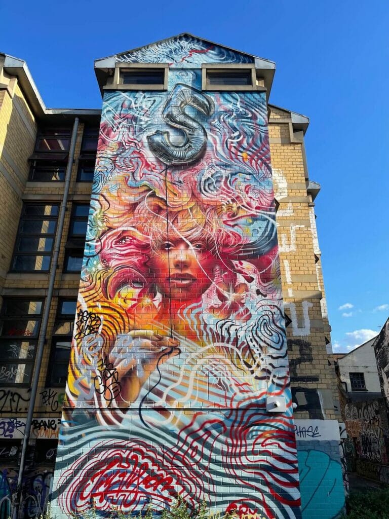 Um prédio coberto com um mural de grafite na Pedley Street, Londres