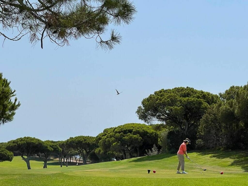 A woman playing golf at Pine Cliffs Resort, Albufeira, Portugal