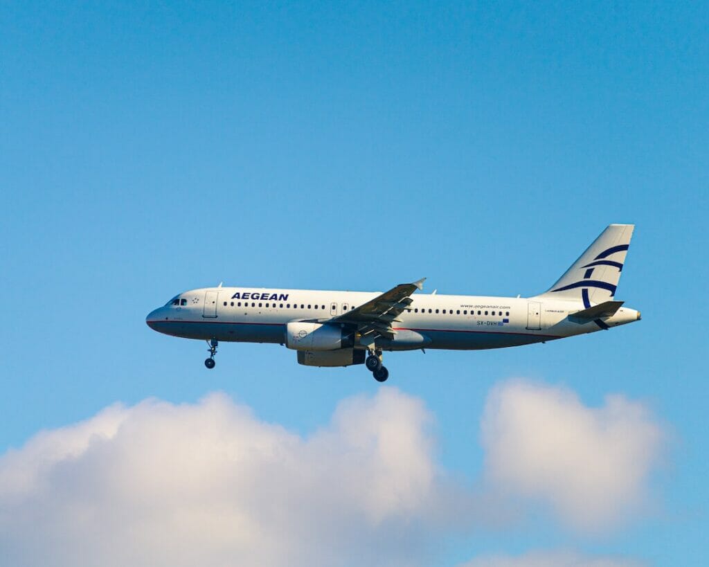 O avião da companhia aérea Aegean Airlines voando no céu