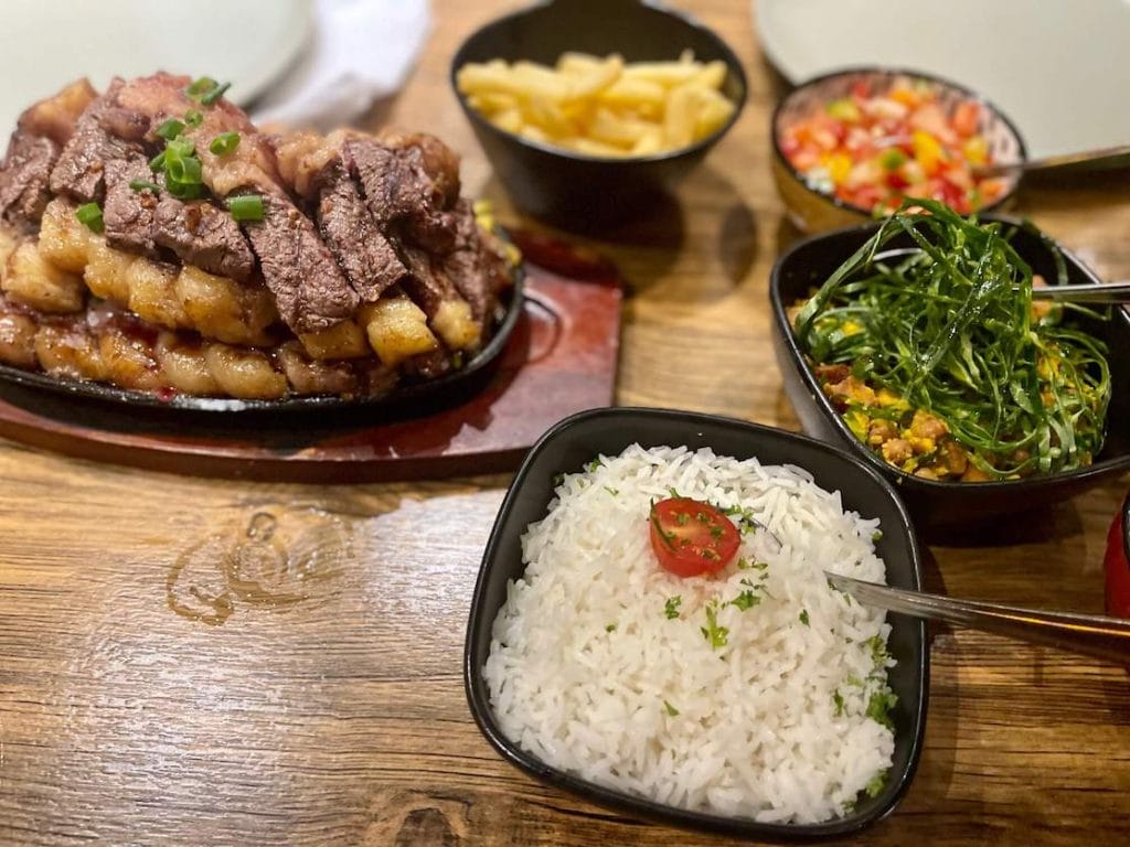 Uma suculenta picanha com arroz, feijão tropeiro, batata frita e vinagrete servida no Restaurante Frigideira, em Londres