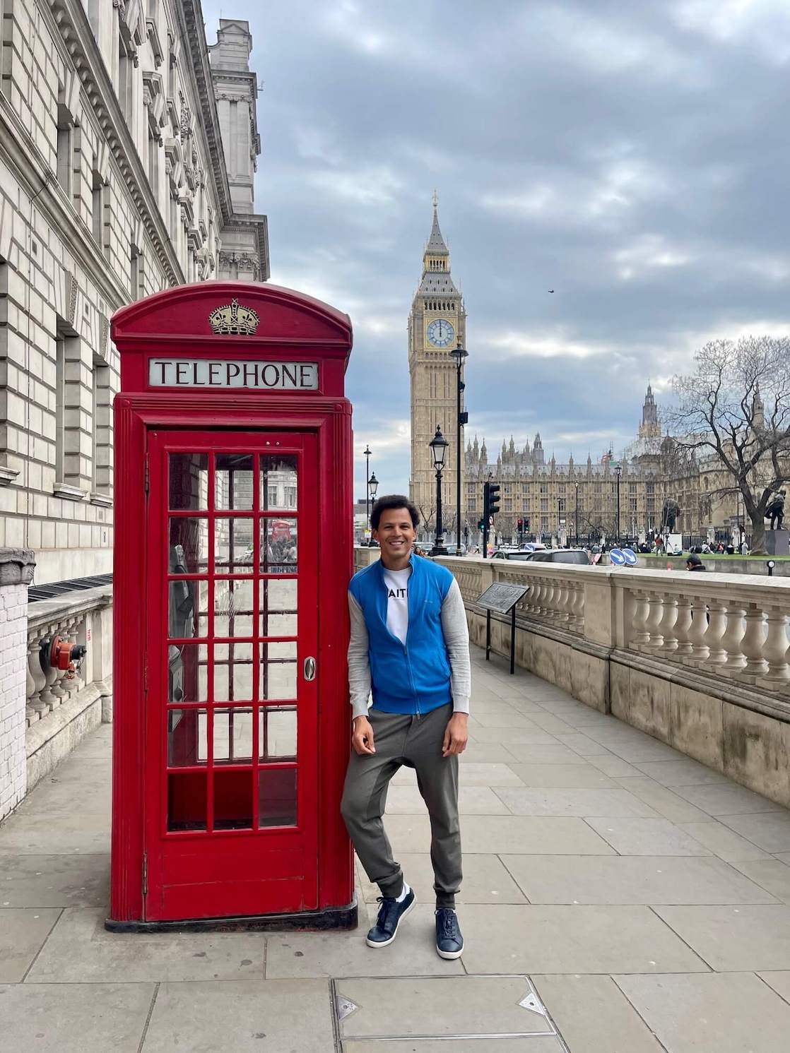 Péricles Rosa pousando para foto encostado em uma cabine telefônica vermelha com o Big Ben de fundo, Londres, Inglaterra