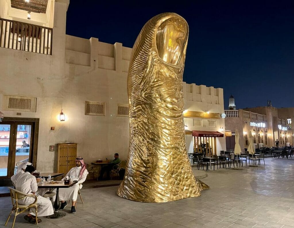 Alguns moradores tomando café perto da Escultura do Polegar de Ouro em Souq Waqif, Doha, Catar