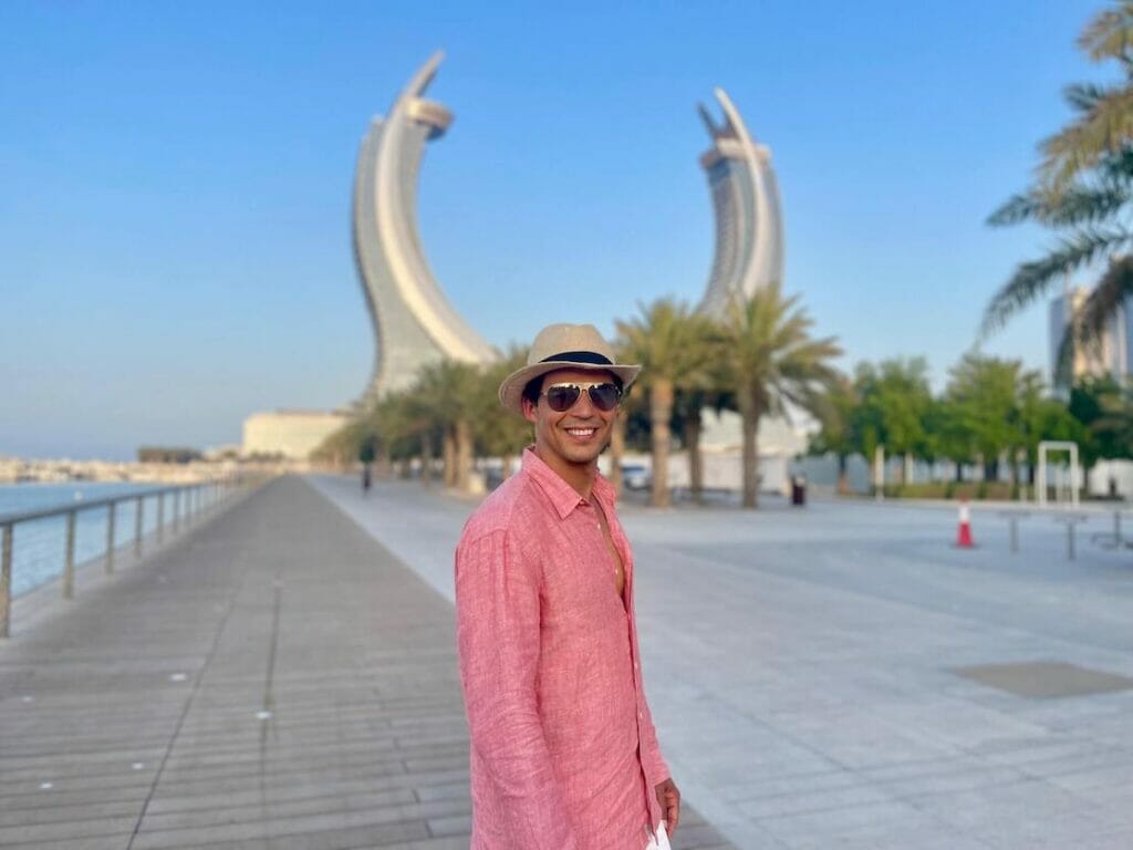 Pericles Rosa con gafas de sol, un sombrero y una camisa de color salmón posando para una foto en Lusail Marina Promenade, Qatar