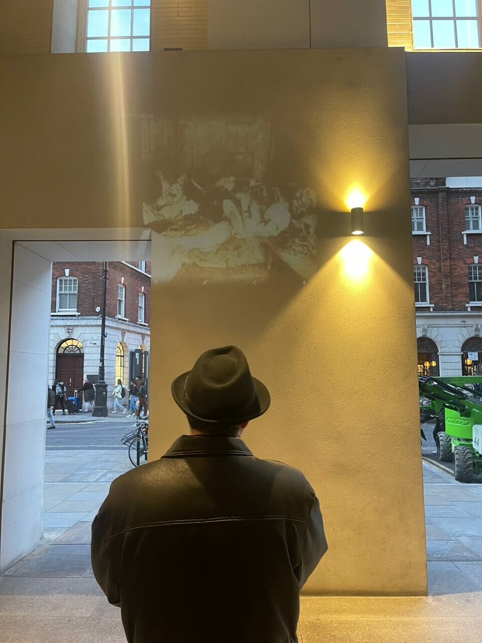 A tour guide projecting a picture on a wall of Mary Jane Kelly's body