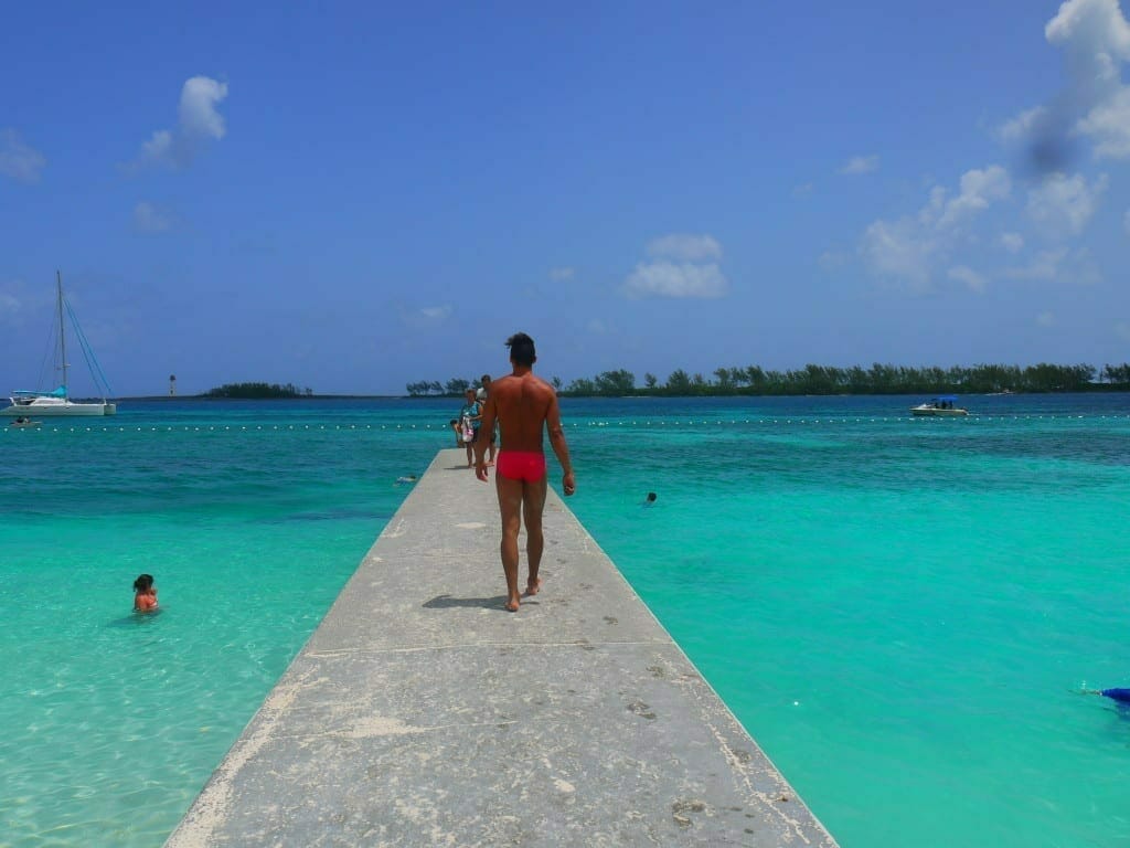 A man walking on a cemented platform on Junkanoo Beach, Nassau, Bahamas