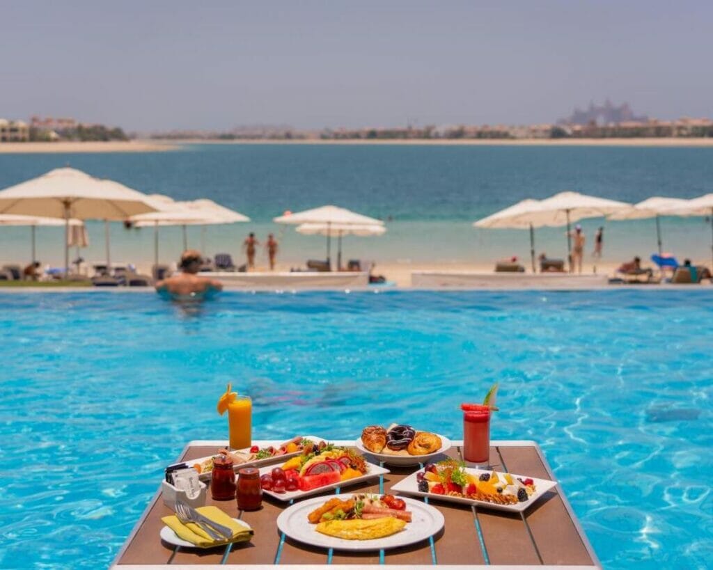 Desayuno servido junto a la piscina del Royal Central Hotel and Resort en Palm Jumeirah Island, Dubái