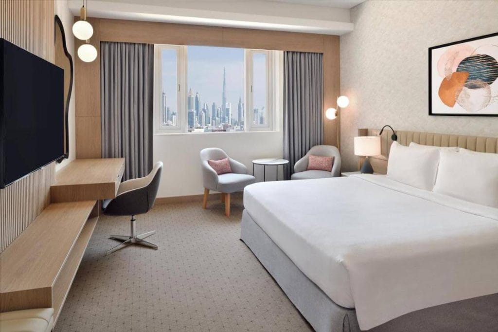 Quarto com cama de casal com secretária, área de estar e vista para Bujr Kalifa no Crowne Plaza - Dubai Jumeirah na Praia de Jumeirah