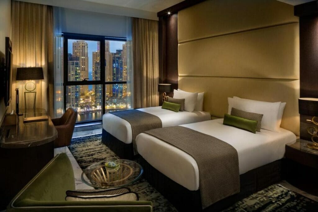 Um quarto com duas camas de solteiro com vista para a cidade no Millennium Place Dubai Marina
