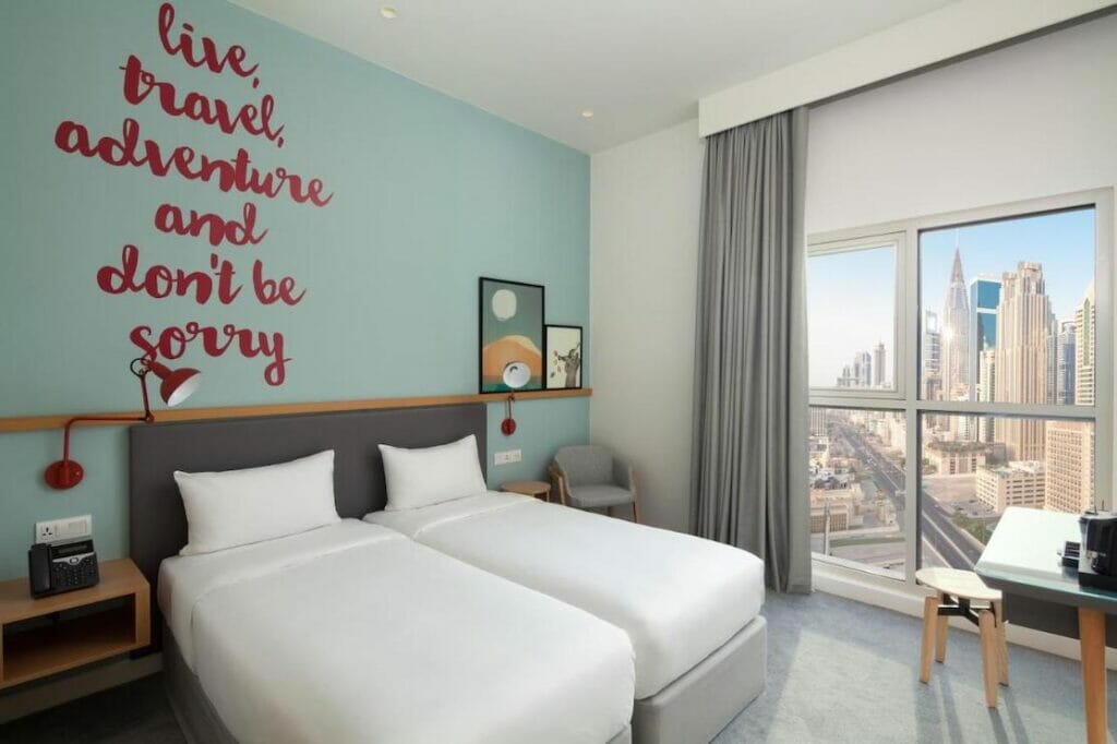 Una habitación de dos camas individuales con vistas a la ciudad en el Rove City Walk Hotel, en el centro de Dubái