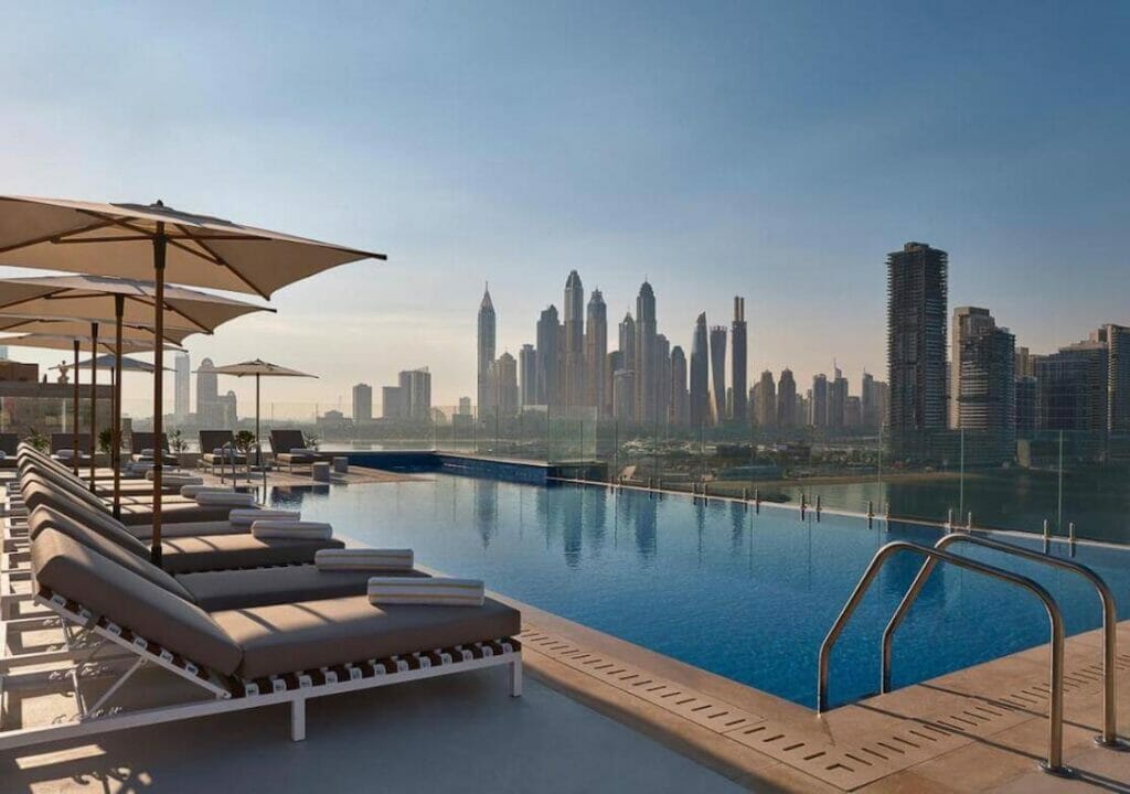 Uma piscina infinita na cobertura com alguns edifícios ao fundo no Voco Dubai The Palm Hotel, Palm Jumeirah Island, Dubai
