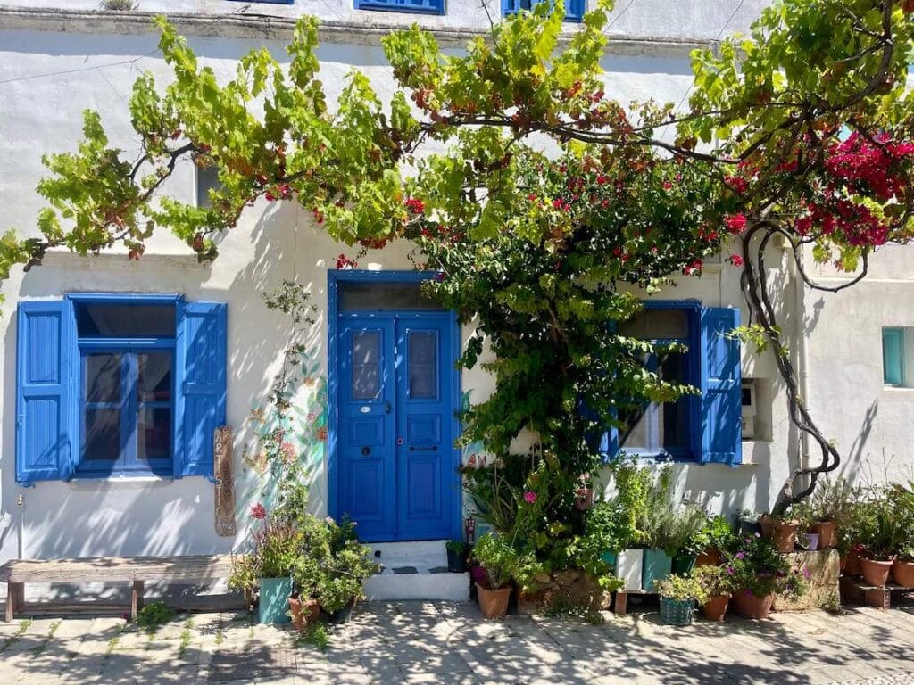 A white-washed house with blue windows and door in the village of Koskinou, Rhodes, Greece