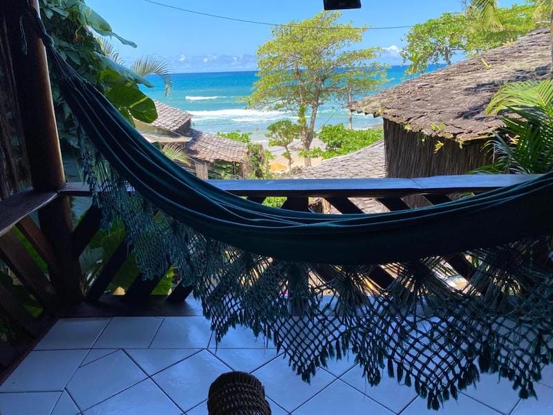 Uma varanda com rede e vista para o mar, na Pousada Hanalei, Itacaré, Bahia, Brasil