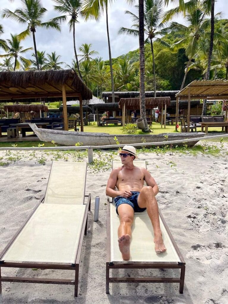 Pericles Rosa wearing a beige hat, sunglasses and blue shorts on a lounge chair at Itacarezinho Beach and Lounge, Itacare, Bahia, Brazil