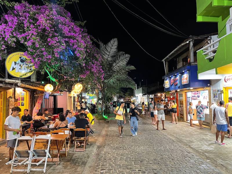 Algumas pessoas andando na Rua Pituba à noite, Itacaré, Brasil