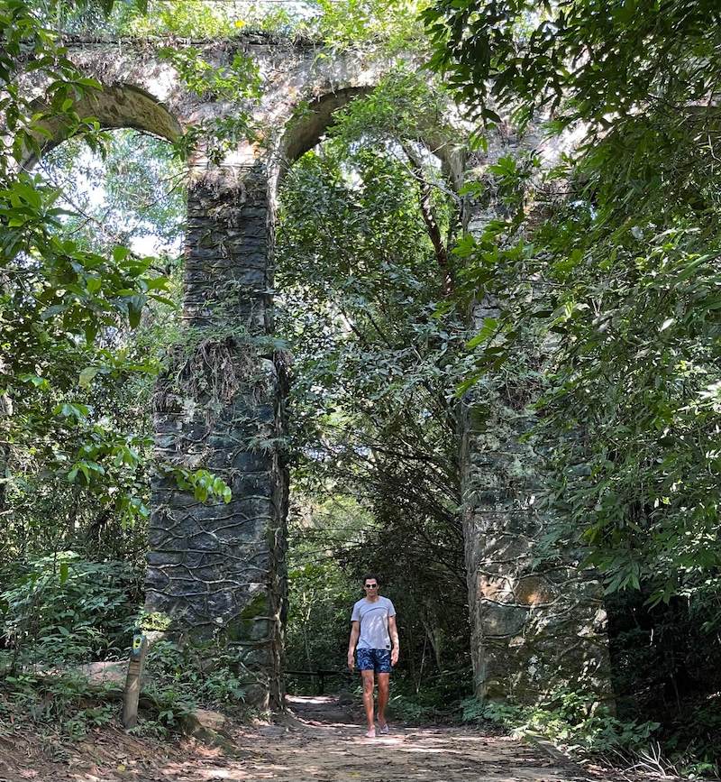 Um homem atravessando os arcos das ruínas do Aqueduto, Ilha Grande, RJ, Brasil